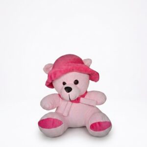 A seated light-pink plush teddy bear wearing a dark-pink ruffled sun hat and a pink bow tie.