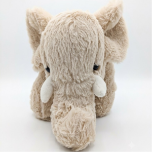 A fluffy, light-beige plush elephant toy in a standing pose, with a long trunk and white tusks.
